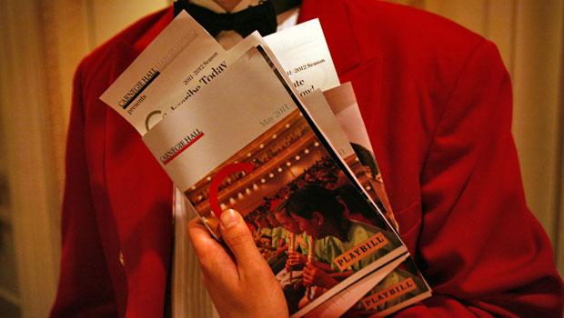 An usher holds Spring for Music programs in Carnegie Hall. An usher holds Spring for Music programs in Carnegie Hall.