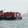 The tugboat Pegasus and the Lehigh Barge no. 79 passing the Statue of Liberty in the rain. The tugboat Pegasus and the Lehigh Barge no. 79 passing the Statue of Liberty in the rain.