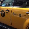 The new taxi logo. A 'T' in a black circle replaces the word 'taxi.'