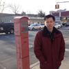 Hsi-Pei Liao at an intersection in Flushing. Behind him is the street where his four-year-old daughter, Allison, was struck and killed by an SUV.