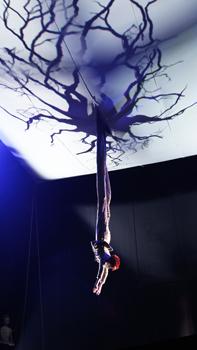 Puck (Kathryn Hunter) descends from a sheet hung above the stage in Julie Taymor’s new production of A Midsummer Night’s Dream at Theatre for a New Audience.