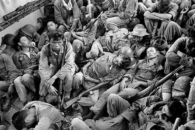Exhausted South Vietnamese soldiers sleep on a U.S. Navy troop carrier taking them back to the provincial capital of Ca Mau, August 1962.