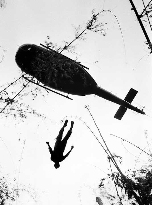The body of a U.S. paratrooper killed in action in the jungle near the Cambodian border is lifted up to an evacuation helicopter in War Zone C, May 14, 1966.