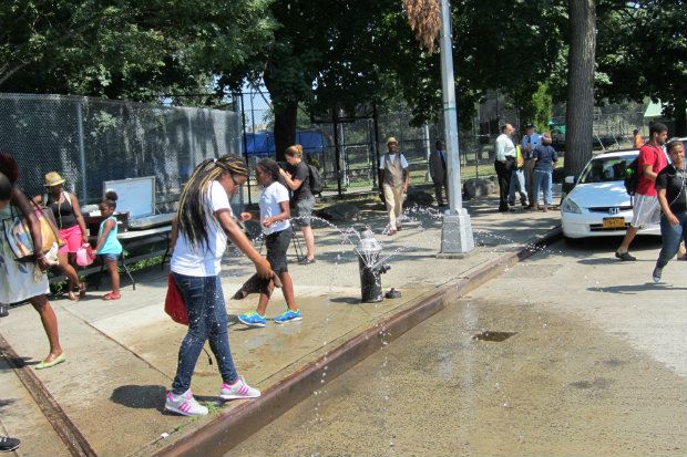 Grand Concourse and 153rd Street, Bronx, DEP demonstrating hydrant with sprinkler cap.