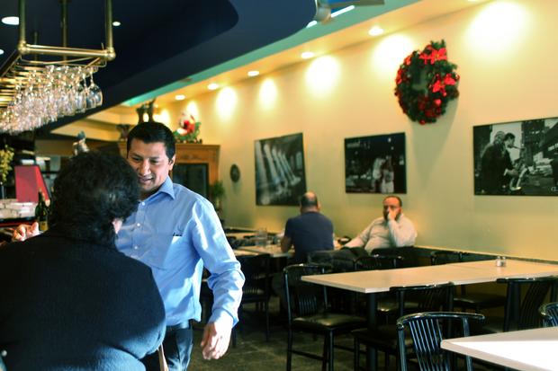 The maitre d' at Cafe Luna greets a regular customer.
