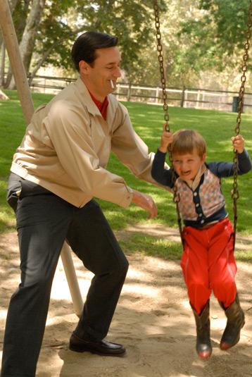 Don Draper from AMC's 'Mad Men', pushing his son, Bobby, on a swing