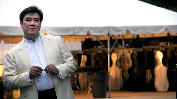 Alan Gilbert, with baton in hand, waits backstage before conducting the New York Philharmonic in Central Park on July 13, 2012.
