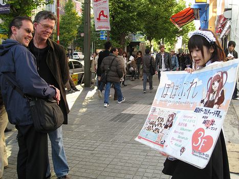 Kurt and Roland spot a young woman advertising a nearby maid cafe.