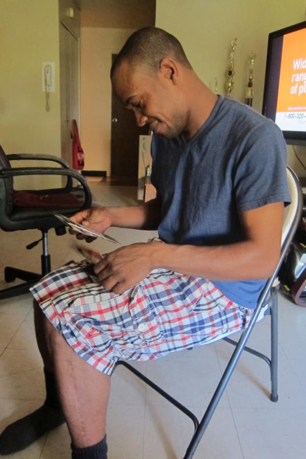Ronald Wallace's father looks at photos of his late son in their Brooklyn apartment. ronald wallace, in harm's way