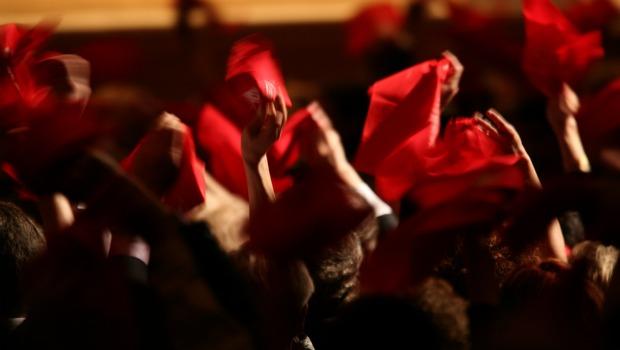 Fans from Toledo wave red hankerchiefs in the audience before the Toledo Symphony and conductor Stefan Sanderling.