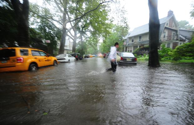 A man makes his way through a flooded street in Brooklyn, New York, August 28, 2011. A man makes his way through a flooded street in Brooklyn, New York, August 28, 2011.