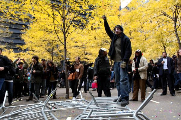 Protester stomps on knocked down barricades around Zuccotti Park.