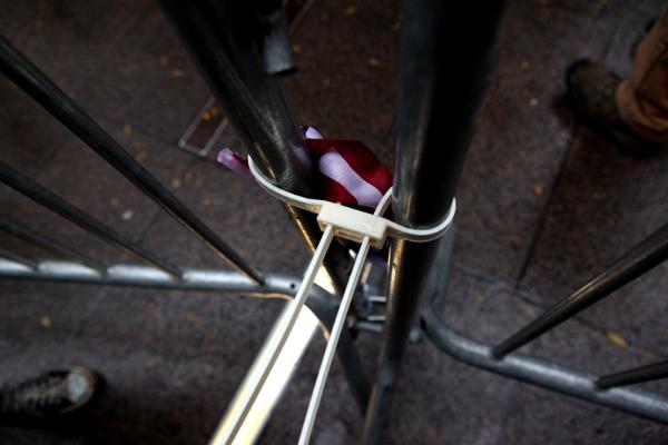 Barriers locked together with handcuffs and an American flag at Zuccotti Park.