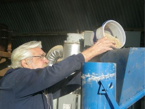 Frank Polifka loads whole wheat into a smaller version of the Windhexe.