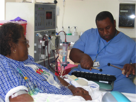 A Shands Hospital staff member plays music for a dialysis patient.