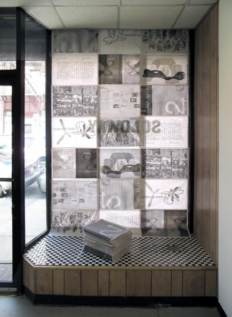 2-UP's newspaper, which will be given away for free, will disassemble into seven different posters. The gallery's window, with a stack of papers, is seen above.