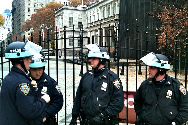 Police in riot gear line up outside City Hall.