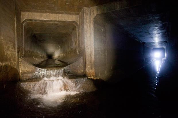Erling Kagge's light in distance in storm drains underneath central Queens. Possible former route of Horse Creek, tributary to Flushing River.