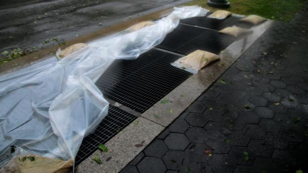 Irene's winds had blown off plastic held down by sandbags meant to keep water out of subway grates. Irene's winds had blown off plastic held down by sandbags meant to keep water out of subway grates.