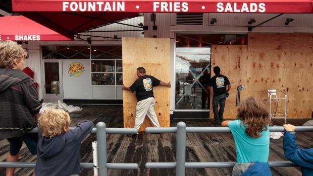Children watch workers remove the plywood from the front windows of the Johnny Rocket's at the South Street Seaport just hours after Hurricane Irene blew through the city August 28, 2011. Children watch workers remove the plywood from the front windows of the Johnny Rocket's at the South Street Seaport just hours after Hurricane Irene blew through the city August 28, 2011.