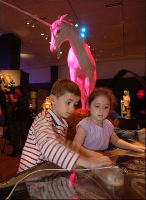 Six-year-olds Aidan Obstler and Sophie Edelman use magnets to arrange mammoth bones to form the skeleton of a mythical giant.
