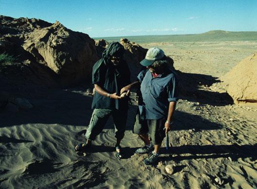 At the Flaming Cliffs in the Gobi Desert of Mongolia, American Museum of Natural History paleontologists Mark Norell (left) and Mike Novacek (right) examine a fossilized oviraptor egg.