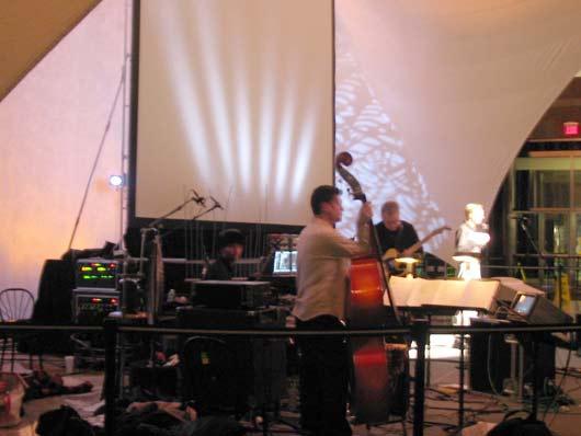 John Schaefer (far R) introduces 'Eclipse', featuring the Bill Frisell trio; percussionist Kenny Wollesen, double bass player Tony Scherr, guitarist Bill Frisell, 1/15/04.