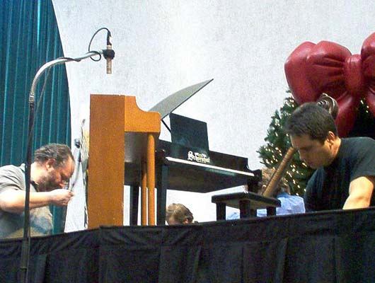 Far left: Senior Concert Engineer Ed Haber sets up the microphone on the toy piano, 12/9/03.
