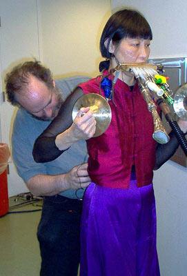 WNYC's Ed Haber outfits soloist Margaret Leng Tan with a wireless microphone for her entrance from the back of the Winter Garden, 12/9/03.