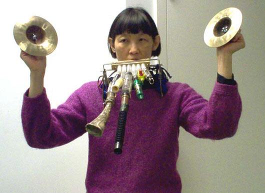 Pianist Margaret Leng Tan with an array of noisemakers strapped to her, 12/9/03.