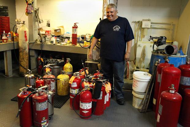 Peter Martinez Jr. with extinguishers at Master Fire Prevention.