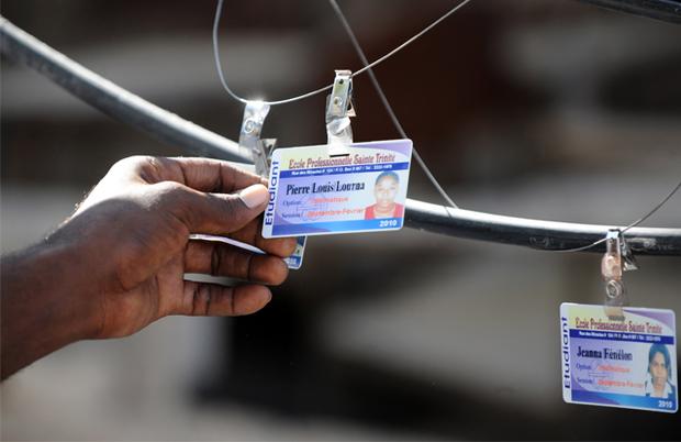 A person looks at identity cards of victims in Port-au-Prince, on January 14, 2010. A person looks at identity cards of victims in Port-au-Prince, on January 14, 2010.