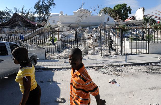 Locals walk in front of the collapsed Palace of Justice in Port-au-Prince, on January 14, 2010. Locals walk in front of the collapsed Palace of Justice in Port-au-Prince, on January 14, 2010.