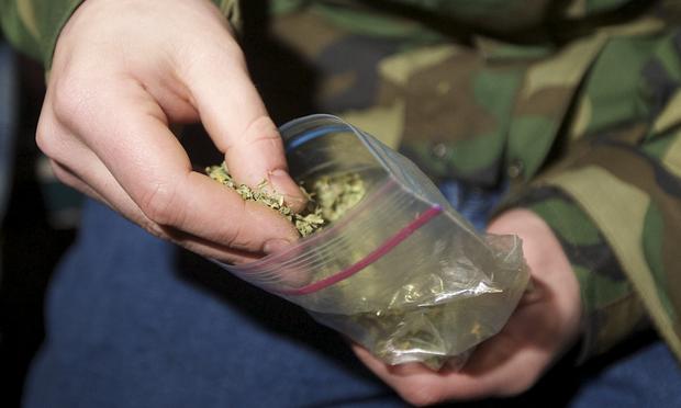 A Seattle resident takes marijuana from a plastic bag shortly after a law legalizing the recreational use of marijuana took effect on December 6, 2012 in Seattle, Washington.