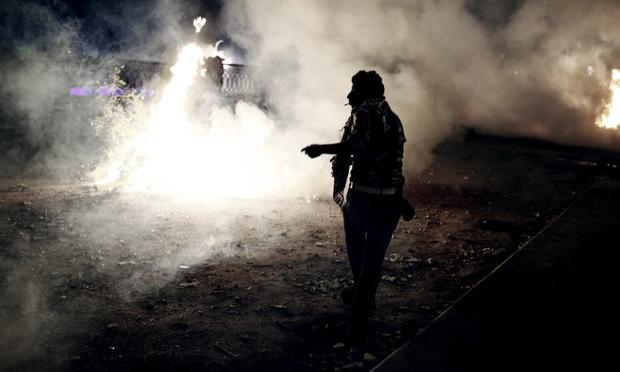 An Egyptian protester stands amongst smoke and tear gas during clashes with riot police near Tahrir Square on January 27, 2013 in Cairo, Egypt.