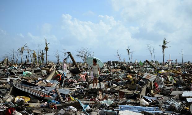 A surivor walks among the debris of houses destroyed by Super Typhoon Haiyan in Tacloban in the eastern Philippine island of Leyte on November 11, 2013.