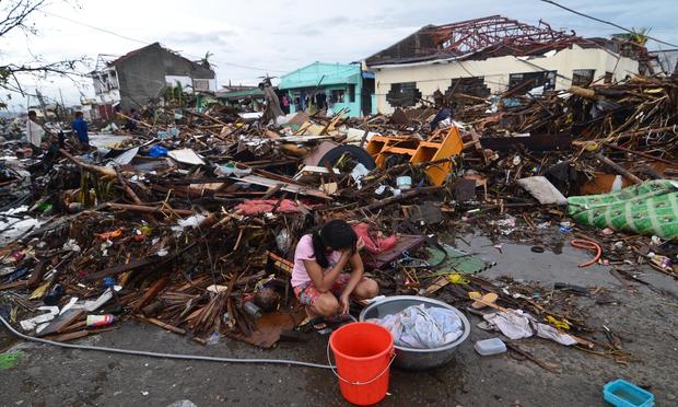 A girl pauses while washing clothes amongst the debris in an area devastated by Typhoon Haiyan on November 12, 2013 in Leyte, Philippines.