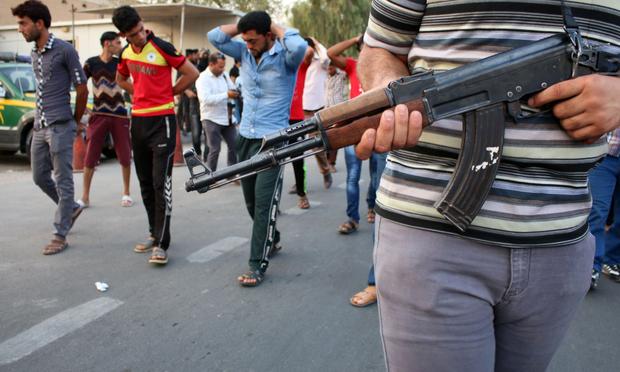 Supporters of the al-Fadila party perform the simulation of an execution during a protest to ask for justice for members of the Iraqi forces who were executed by ISIS. Sept. 3, 2014