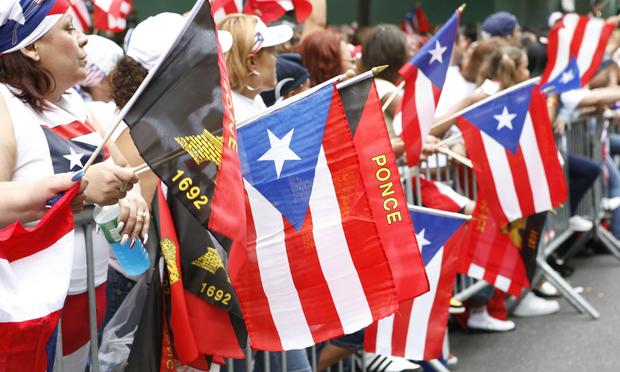 People wave flags during the National Puerto Rican Day Parade in New York City. National Puerto Rican Day Parade