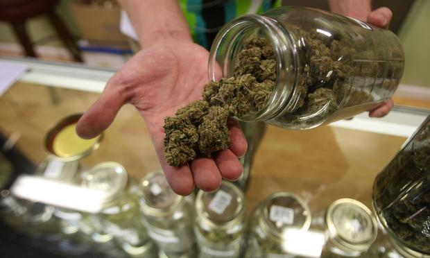 Dave Warden, a bud tender at Private Organic Therapy (P.O.T.), a non-profit co-operative medical marijuana dispensary, displays various types of marijuana available to patients on October 19, 2009.