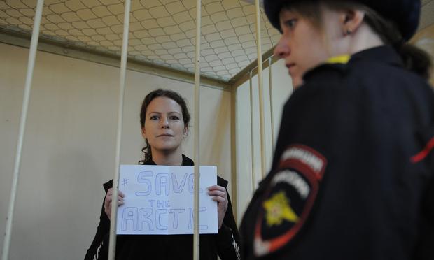 Greenpeace International activist, one of the 'Arctic 30,' Ana Paula Alminhana Maciel from Brazil, holds a poster in a defendant cage in a court in Saint Petersburg, Russia, November 18, 2013. Greenpeace International activist, one of the 'Arctic 30,' Ana Paula Alminhana Maciel
