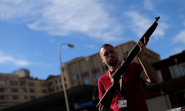 Second Amendment supporter and gun enthusiast Shade Haddox displays an unloaded rifle being sold in an impromptu auction across the street from a gun buy back program in Dallas, TX, Jan 19, 2013 Guns Second amendment