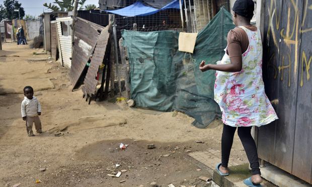 A woman walk in a dusty alley in the impoverished Diepsloot township outside Johannesburg on April 16, 2014. A woman walk in a dusty alley in the impoverished Diepsloot township outside Johannesburg on April 16, 2014.