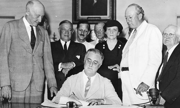 President Franklin Delano Roosevelt signs the Social Security Act on August 14, 1935