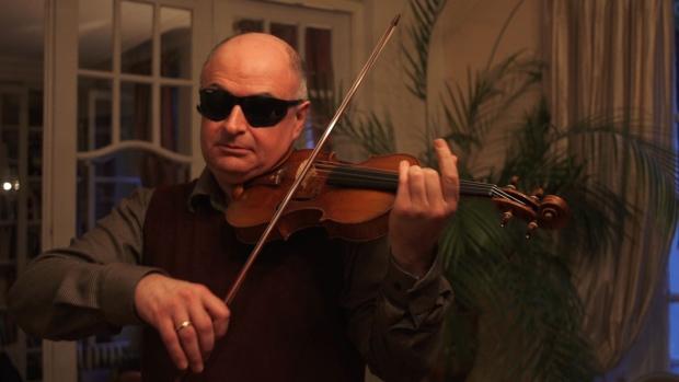Soloist Ilya Kaler tests a violin during the study. Kaler wears modified welder goggles to prevent instrument identification by eye. Soloist Ilya Kaler tests a violin during the study. Kaler wears modified welder goggles to prevent instrument identification by eye.