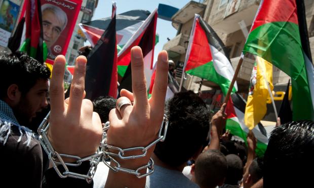 Palestinians marching in Ramallah wear chains around their wrists to symbolize their solidarity with prisoners incarcerated by Israel, May 15, 2012.