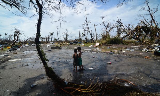 Two young boys look at the devastation in the aftermath of typhoon Haiyan on November 10, 2013 in Tacloban City, Leyte, Philippines. Typhoon Haiyan, packing maximum sustained winds of 195 mph.