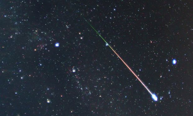 A meteor streaks through the night sky.