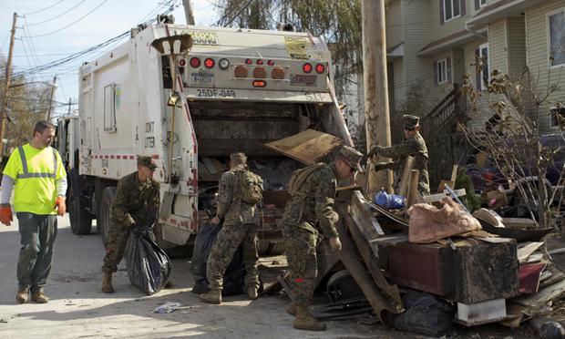 Members of the National Guard team up with a sanitation worker to clear debris on Staten Island after Sandy.