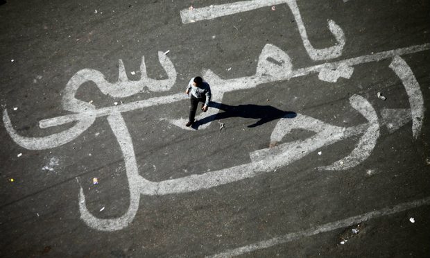 An Egyptian man walks over a graffiti reading 'Morsi Go' on November 25, 2012 at Egypt's landmark Tahrir square in Cairo.